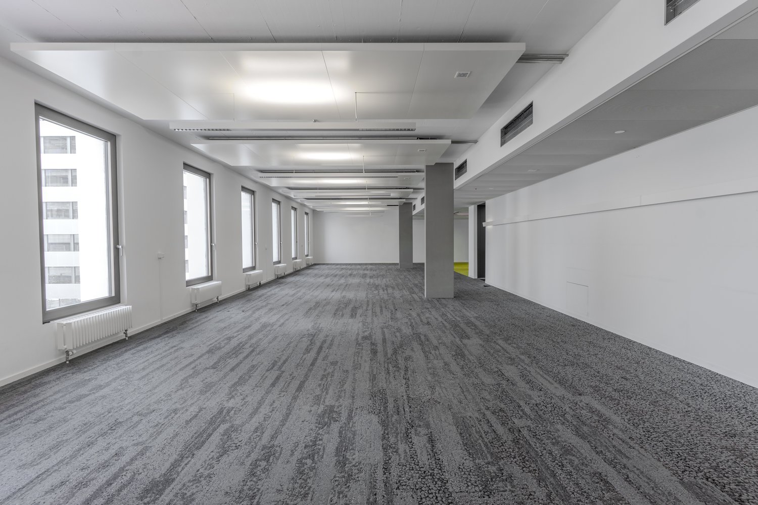 wide hallway, white walls, large windows, gray carpet