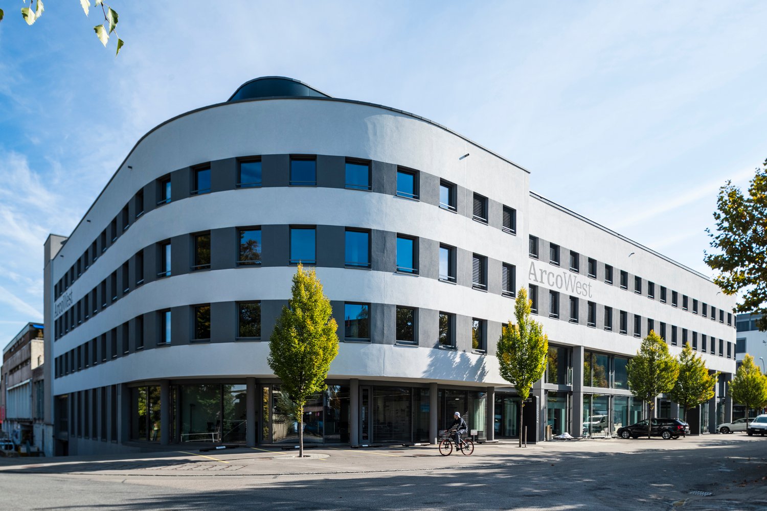 modern architectural style, large windows, ArcoWest name, glass entrance