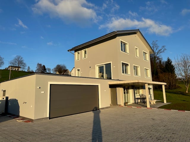 2 story house, beige exterior, large garage, brick driveway