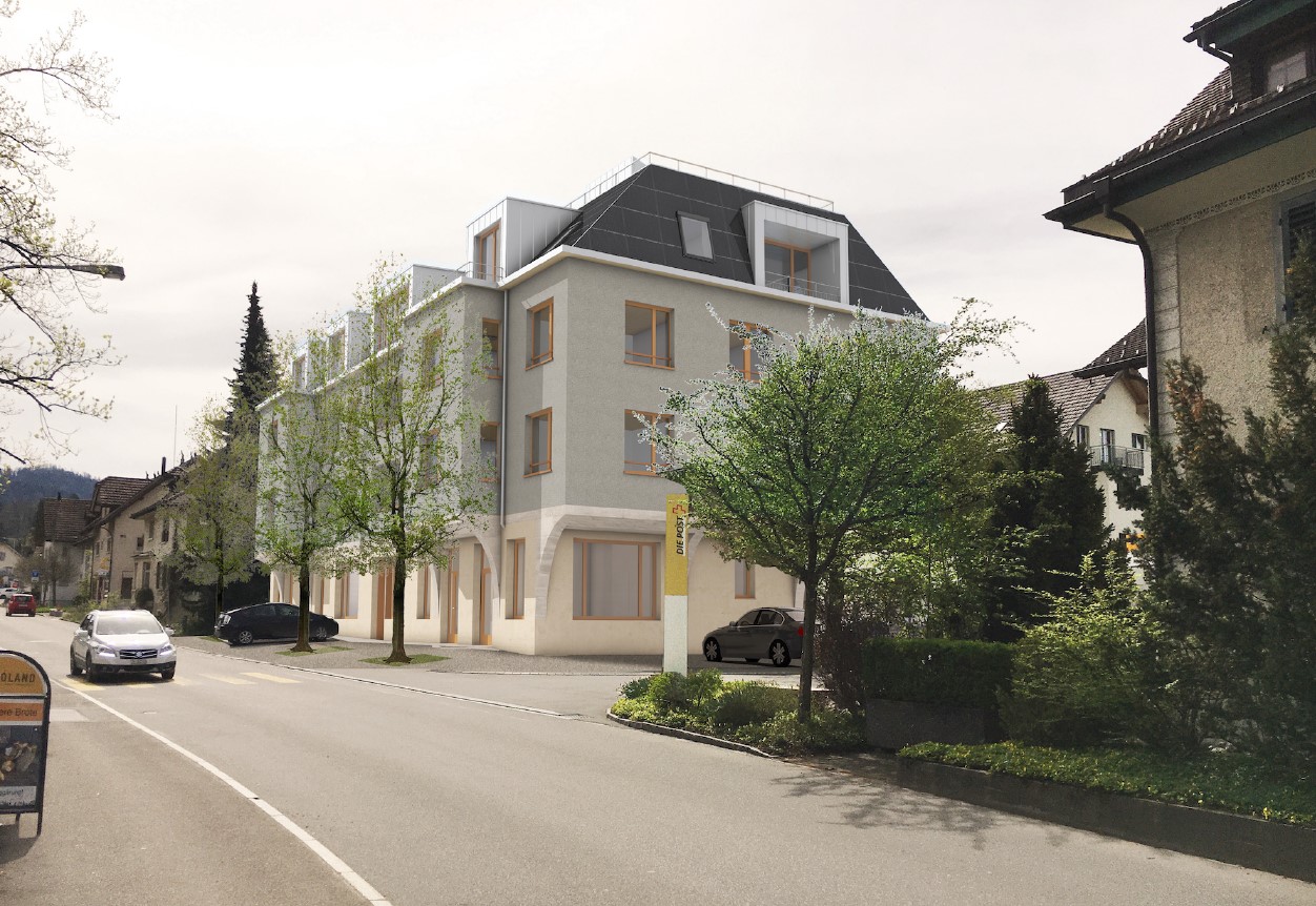 4-story apartment building with a modern design, gray exterior walls, and large windows. The building is surrounded by trees and landscaping, and there is a parking area in front of the building.
