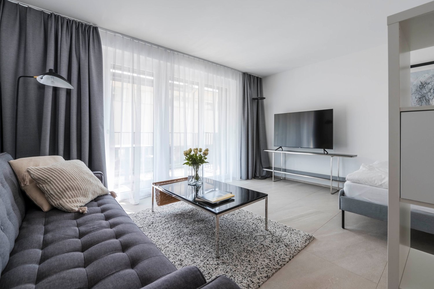 modern design, neutral colors, sofa, coffee table, TV, window with balcony