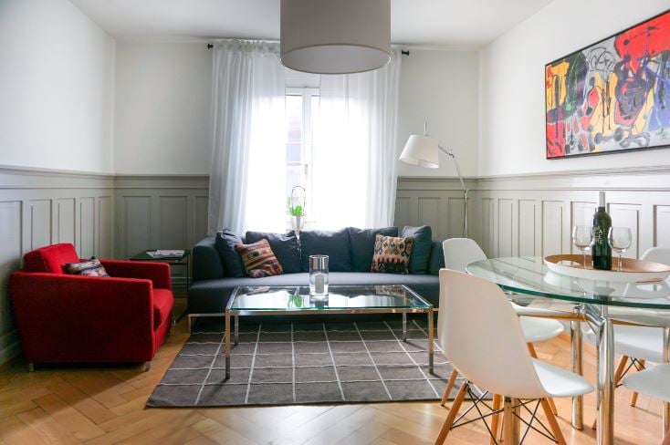 Living room with couch, coffee table, and chairs around a glass dining table