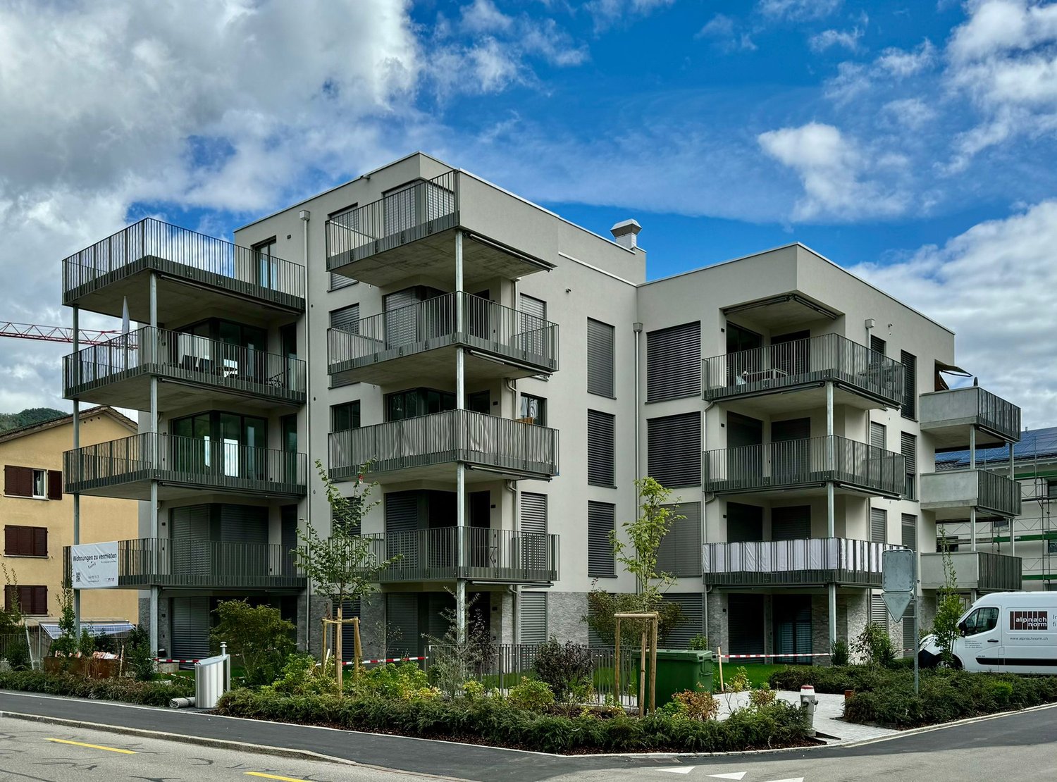 4-storey apartment building, balconies, concrete construction, solar panels, green rooftops