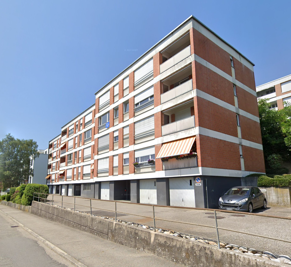 5 story apartment building, brick and white wall, balconies, car parked in front