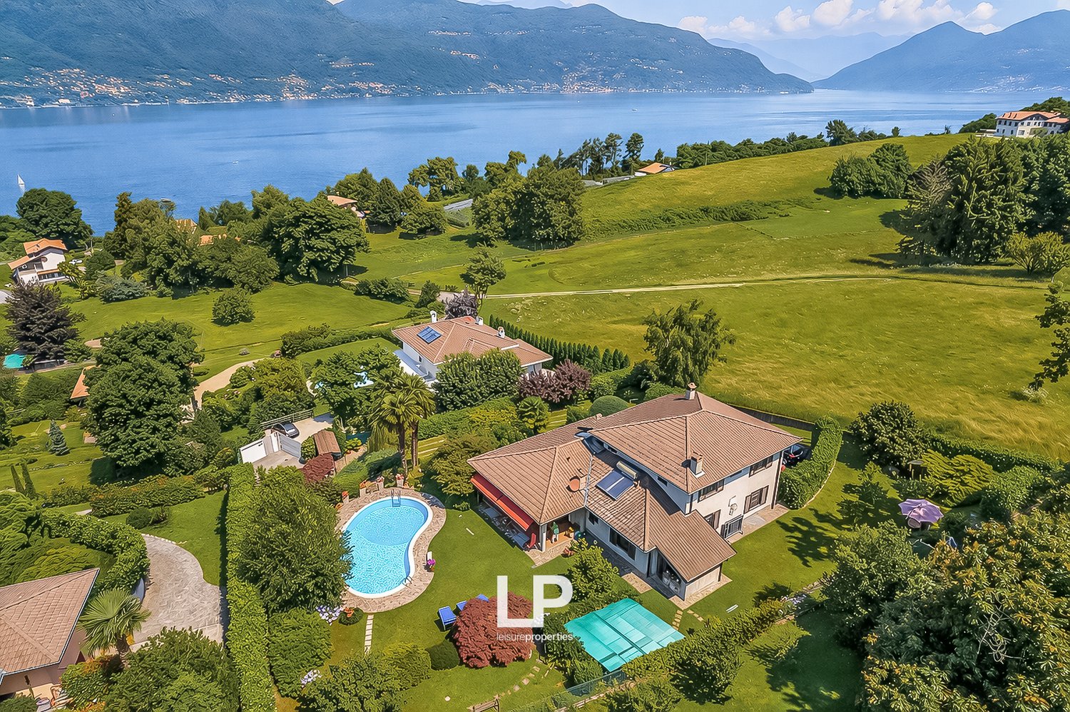 House with swimming pool, located in a green area with a lake view