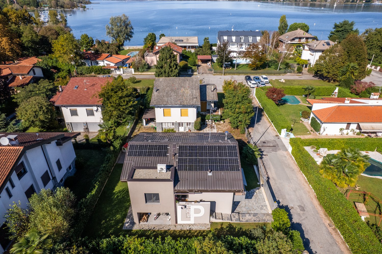 House with solar panels on the roof, located on the lakefront, red tile roofs, fenced gardens
