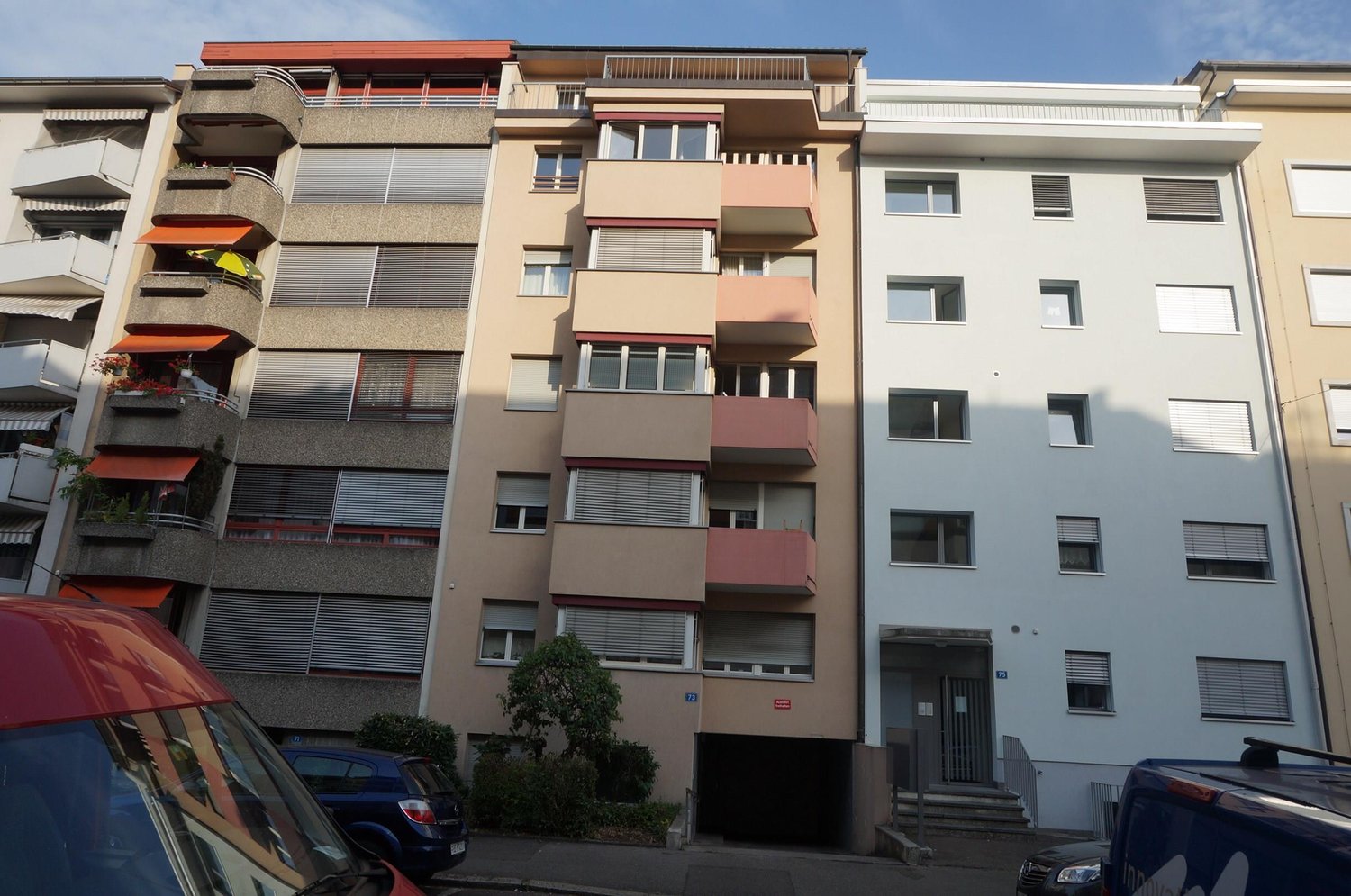 Multi-story apartment building, balconies, underground parking, entrance