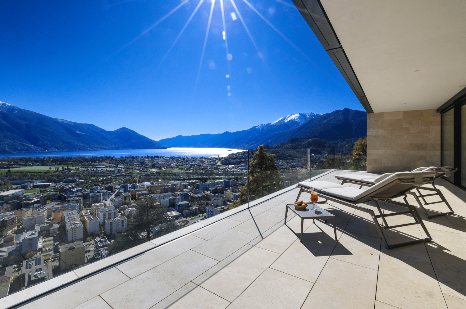 Terrace with lounge chairs, table, and a view of the city and lake