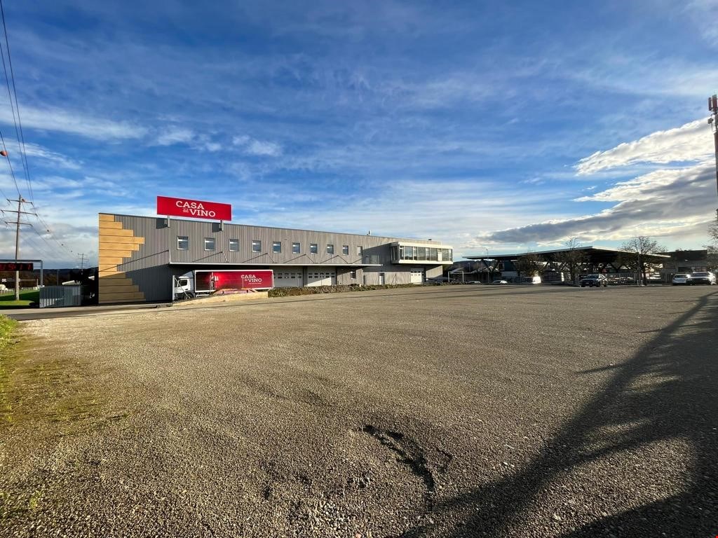 two story building, large open parking area, red sign
