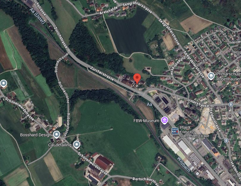 Aerial view of a residential area with various streets, buildings, and green spaces, including a school and a museum.
