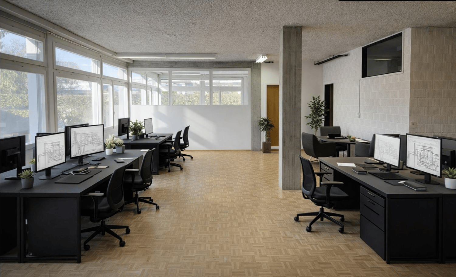 modern office setup, black desks, black swivel chairs, white walls, large windows, plants, and monitors