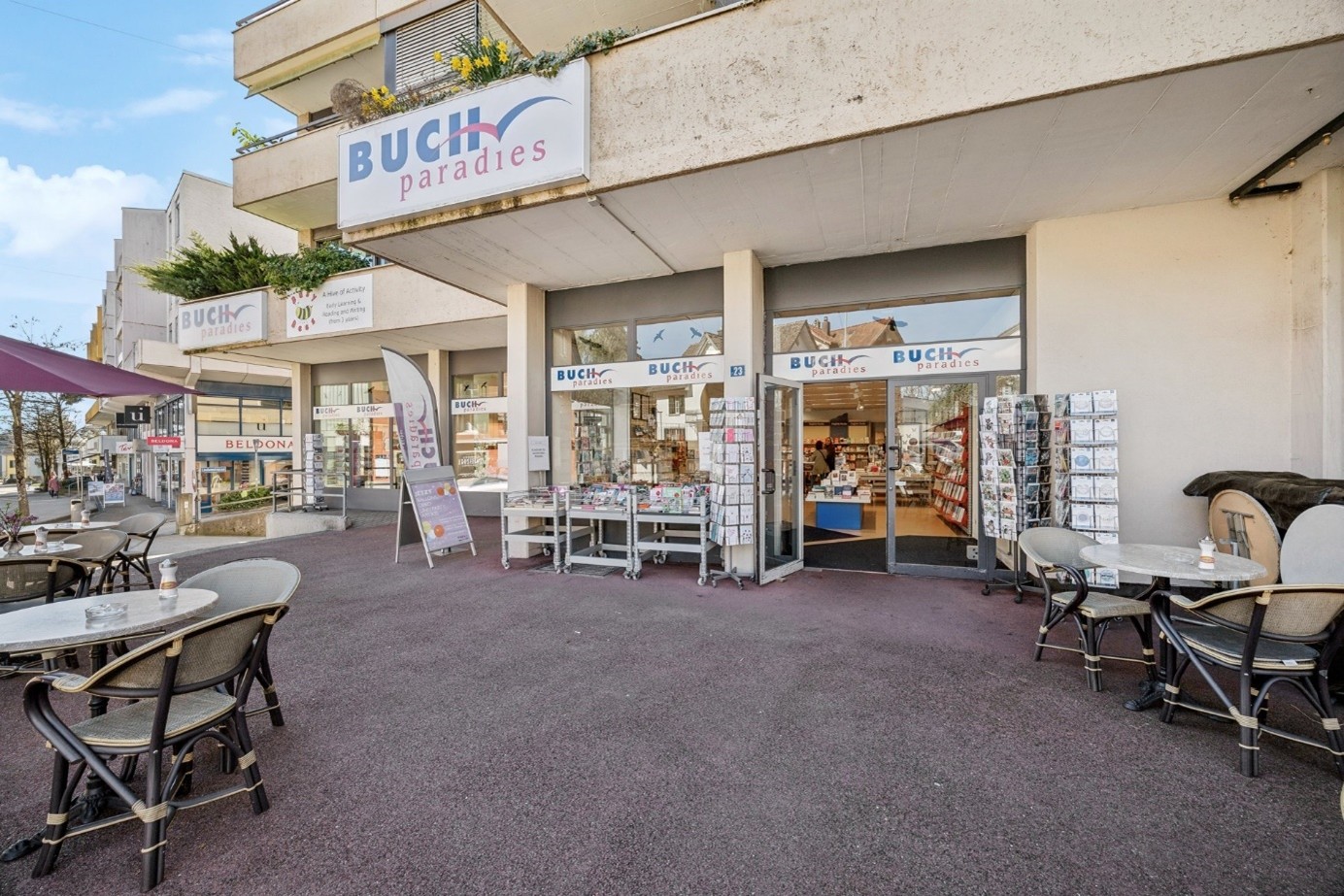 Buch paradies retail store with outdoor seating area, displays of books and other merchandise in the storefront windows