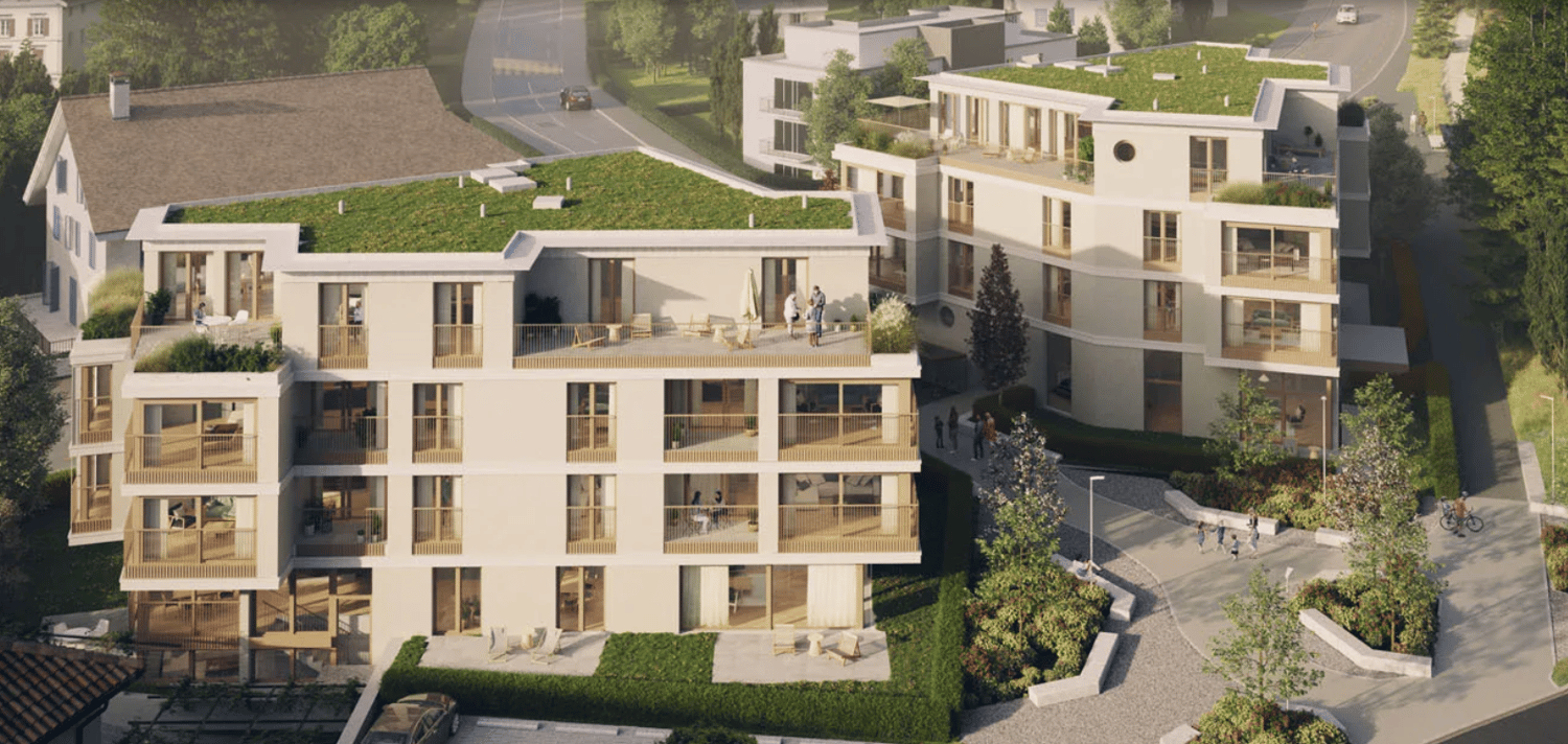 An aerial view of a 3 story house, with green roofs and balconies on each floor, located in a landscaped area with greenery and pathways.