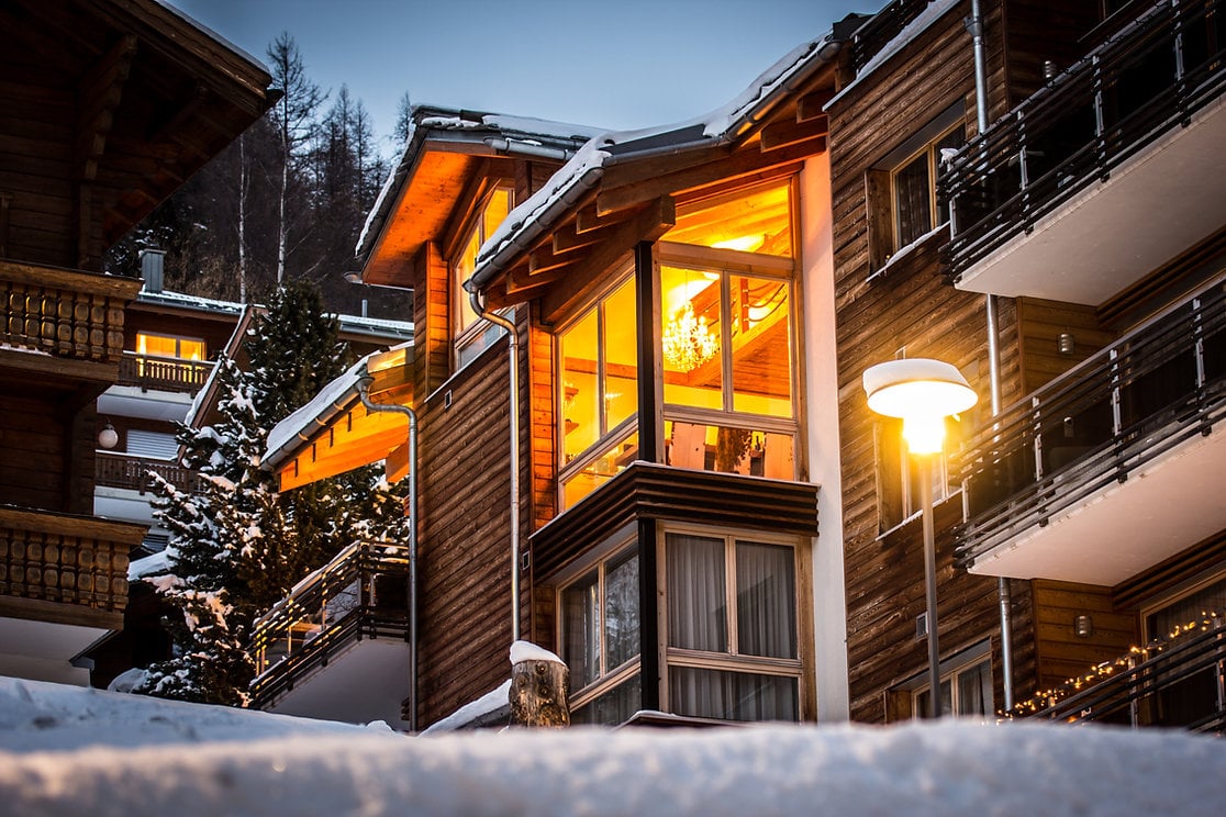 Wooden chalet style, multi-storey, balconies, illuminated windows, street lighting