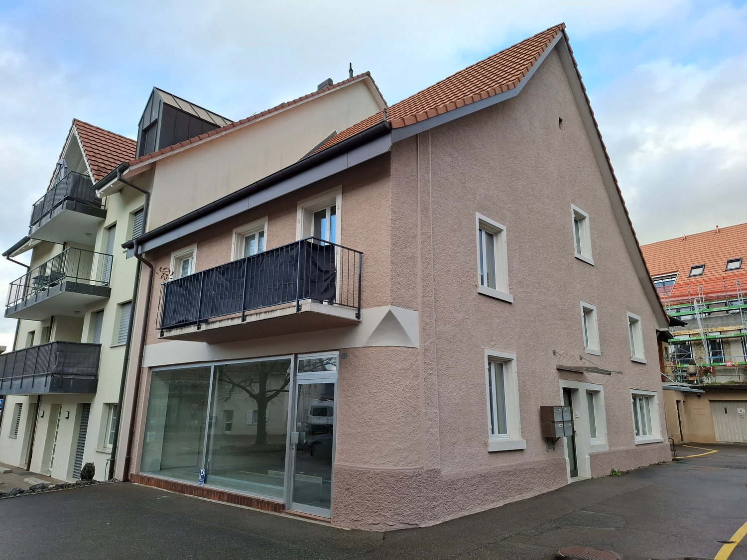 3 story house, brown roof, glass windows, glass door, balcony, glass wall