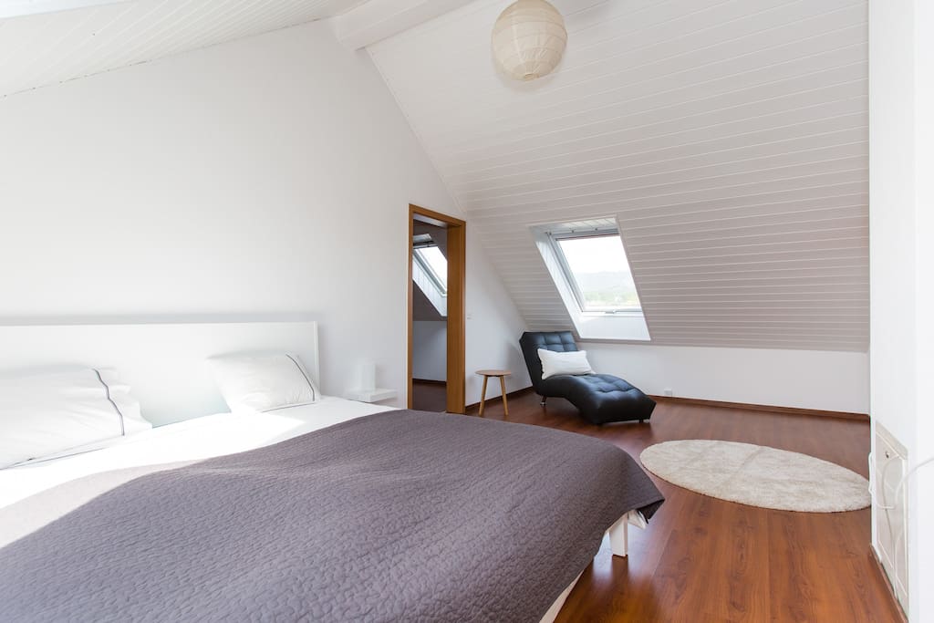 bedroom with a bed, pillows, duvet, and white rug