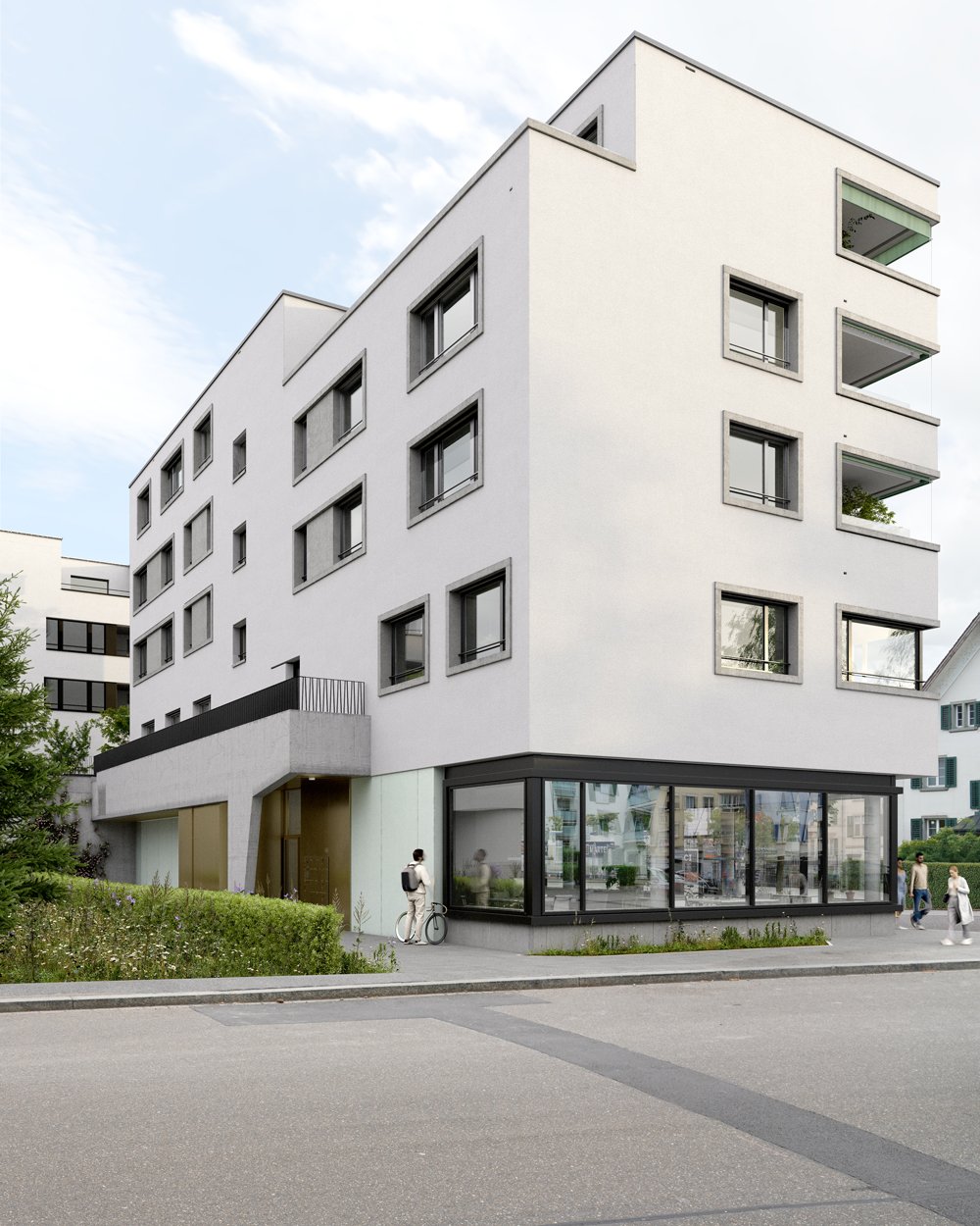 Modern white building, multiple windows, ground floor with glass walls, balcony on the second floor, greenery around